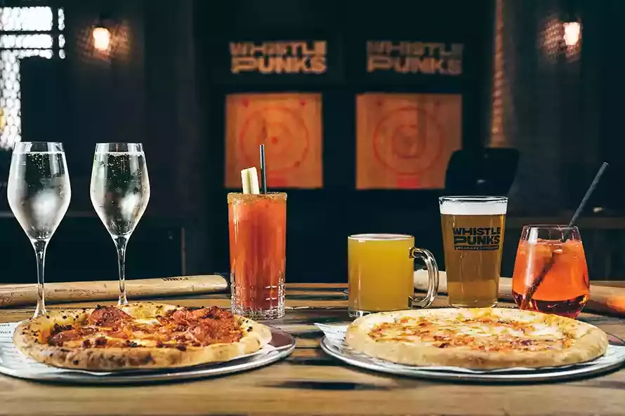 Drinks and pizza on the table for bottomless brunch at Whistle Punks Leeds